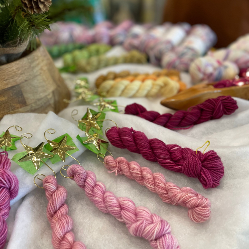 Mini skeins from the Advent collection featuring jewel tones such as plum, berry, and deep blue.