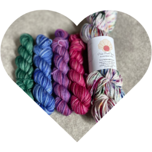 Candlelight Collection Advent yarn set with four mini skeins for Hope, Peace, Joy, and Love beside a full DK weight skein