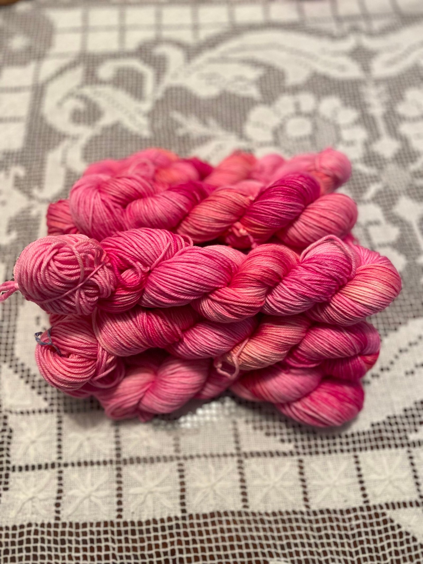 DK Stack of Heart Rest pink hand dyed yarn skeins in blush and berry tones.