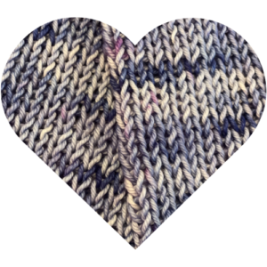 Close-up of indigo blue and violet hand dyed yarn knitted into fabric, shown in heart shape from The Longing Winter Hymn Collection.